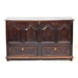 A George III four panel oak mule chest, hinged top over four shaped fielded panels, above two