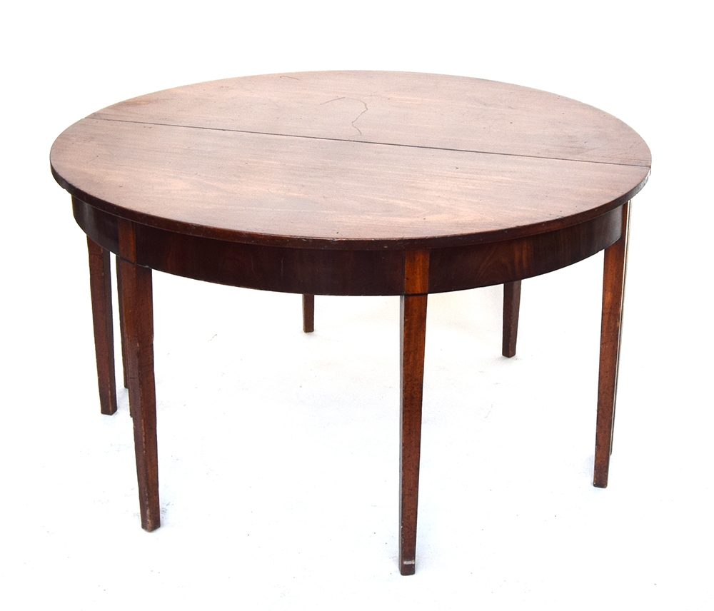 A George III mahogany D-end dining table with ebony stringing, on square tapered legs, with complete