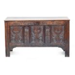 A 17th century three panel oak coffer, the front initialled 'I B' and carved with floral motifs,