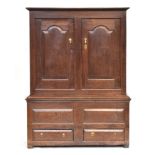 A George I oak press cupboard, enclosed by a pair of arched fielded-panel doors, the base with two