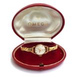 A ladies gold Omega watch on yellow metal bracelet. In original box and with paperwork