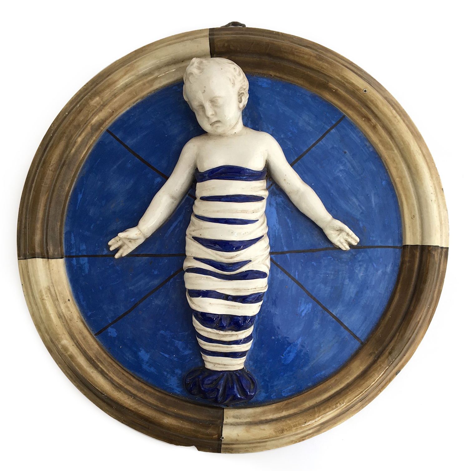 An Italian pottery wall plaque after Andrea Della Robia depicting a swaddled infant, based on the