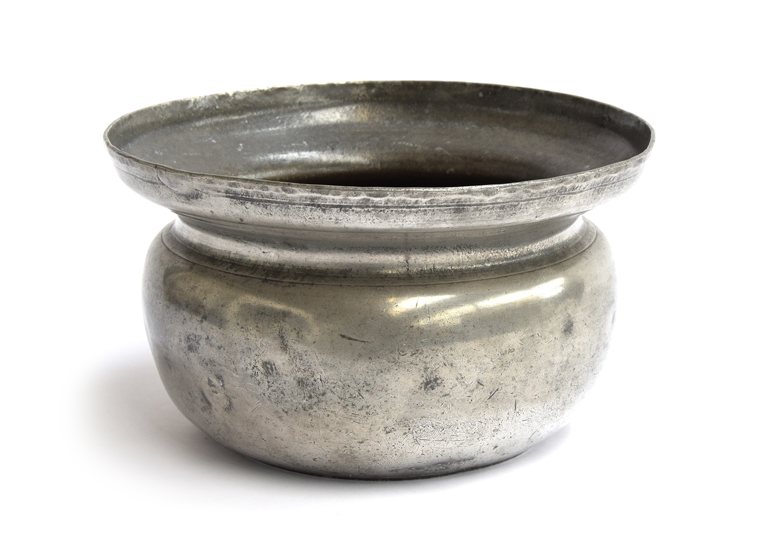 A mid-18th century pewter chamberpot, bears touchmark 'IM', circa 1750, 22cm diameter A similar