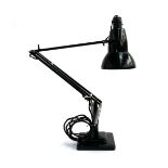 A black Herbert Terry anglepoise lamp on a stepped square base