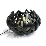 A pierced black resin table lamp with central orb shade, approx. 45cm wide