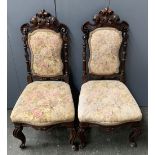 A pair of Italian carved and upholstered hall chairs, on scrolling cabrioles