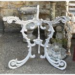 A white painted wrought iron scrolling garden table base, 66cmH, with matched top and grape and vine