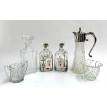 Two Holme Gaard rounded rectangular Christmas decanters, together with a square decanter, plated and