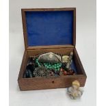 A carved wooden box containing a small amount of jewellery, to include a hallmarked 9ct gold