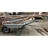 A galvanised wheelbarrow; together with a quantity of vintage garden tools, to include pickaxe,