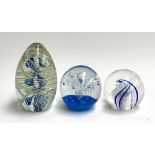 Three blown glass paperweights, largest 14cm high