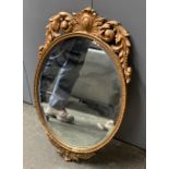 An oval gilt framed wall mirror with bevelled glass, 68cmH