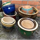 A quantity of glazed ceramic planters of various sizes