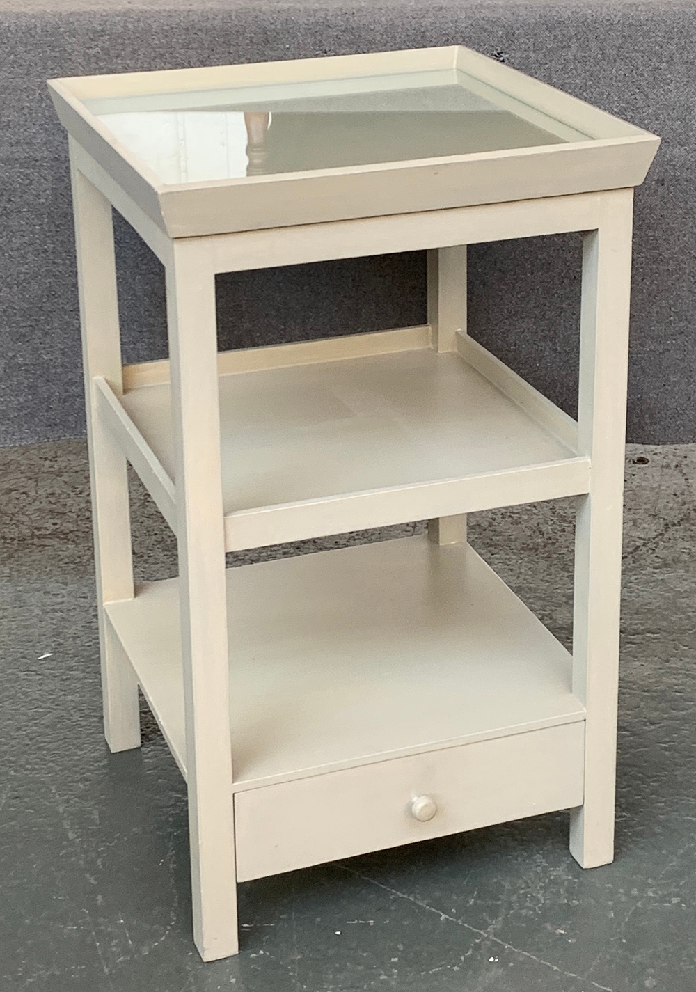 An OKA bedside cabinet, galleried glass inset top, over two shelves and drawer, 43x43x71cm