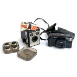 A Kodak Brownie Flash III box camera; a Pentax 35mm camera; and a set of IBM golfball typewriter