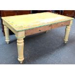 A distressed painted low pine farmhouse table, with two drawers, on substantial turned legs,