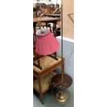 A floorstanding brass lamp, adjustable height, with turned dished shelf