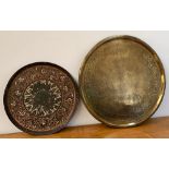 An Indian brass tray, worked with various figures and motifs, 59cmD; together with one other