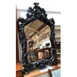 A large shaped wall mirror with ornate cast resin frame, 140cmH