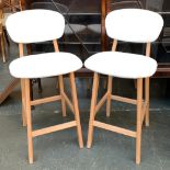 A pair of contemporary white vinyl and beech barstools, height of seat 65cmH