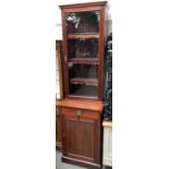 An early 20th century glazed bookcase of three shelves, with leather aprons, on a base comprising