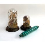 Two glass cloches on turned wooden bases each with a dried floral arrangement, 30cmH and 21cmH;