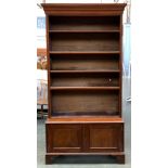 An early 20th century mahogany bookshelf of four adjustable shelves, with cupboard doors below on