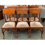 A set of six Edwardian mahogany dining chairs, deep rail over solid upholstered seats, shaped