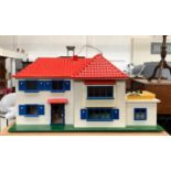 A dolls house with red plastic roof, containing a quantity of furniture, 84cmW