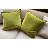 A pair of green velvet cushions, with purple piping, approx. 50cm2