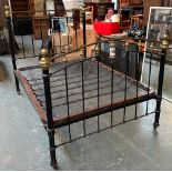 A cast iron and brass double bed, with sprung base, on casters, approx. 4'6", the head 150cmH