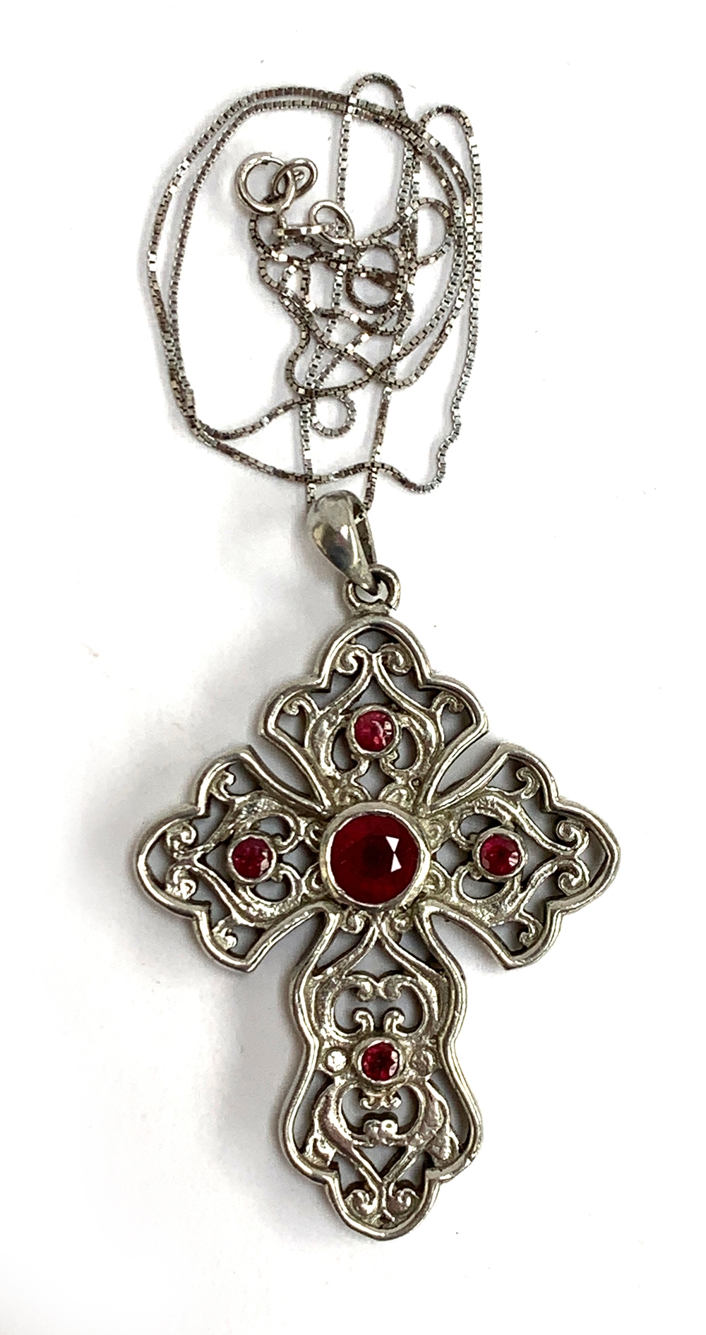 A Stephen Whittard pierced pewter cross set with garnets, 6cmL on a 925 silver chain, 46cmL