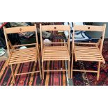 A set of three beechwood folding chairs