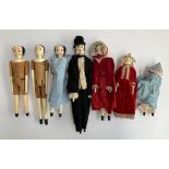 A lot of seven wooden peg dolls with painted faces, the tallest 32cm