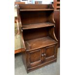 An Ercol oak waterfall bookcase, with cupboard below, 61cmW