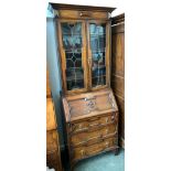 A lead glazed oak bureau bookcase, three shelves over fall front and three geometric drawers,