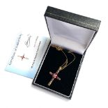 A 9ct gold pierced crucifix set with four rubies and a diamond, approx. 2.75g, with box