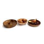 Three turned wood bowls containing a quantity of wooden fruit