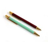 Two Must de Cartier ballpoint pens, with twist action, in maroon and cyan (2)