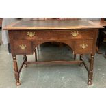 An early 20th century oak desk, with single drawer and kneehole flanked by two further drawers, on