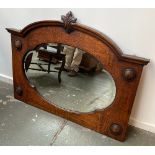 An oak wall mirror with bevelled shaped plate, applied mouldings, 102cmW