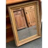 A gilt gesso picture frame with mirrored plate, the internal dimensions 66x45cm