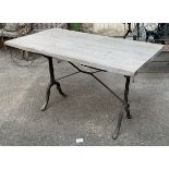 A wrought iron garden table, with three plank wooden top