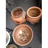 Two terracotta strawberry planters together with a terracotta pot