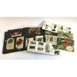 A postcard album, together with a quantity of Brooke Bond cigarette cards