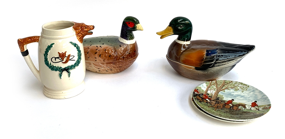Duck and pheasant lidded tureens, together with two Poole pottery plates with Herring hunting