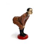 A novelty Adolf Hitler cold painted figural pin cushion, realistically modelled bent-over with his