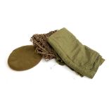 A military issue wool blanket, beret, and camouflage netting