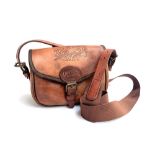 A brown leather cartridge bag with adjustable strap