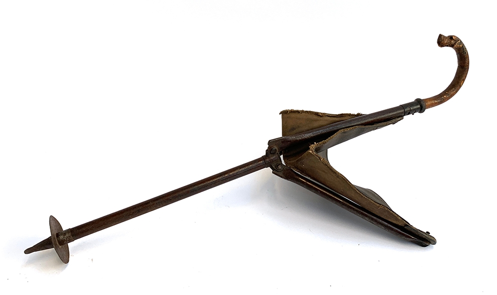 In the style of Swaine & Adeney, a shooting stick with leather and canvas seat, the handle carved in